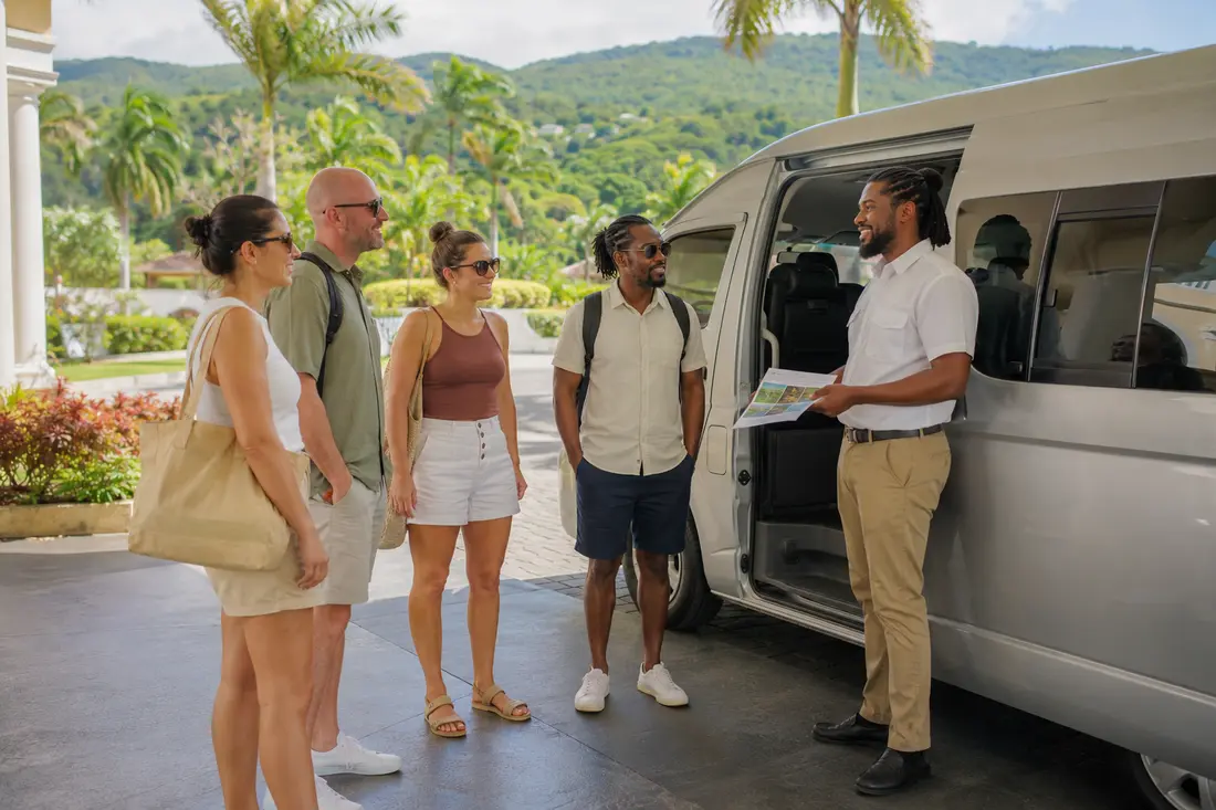 Tourists meeting a private guide beside a tour van in Montego Bay